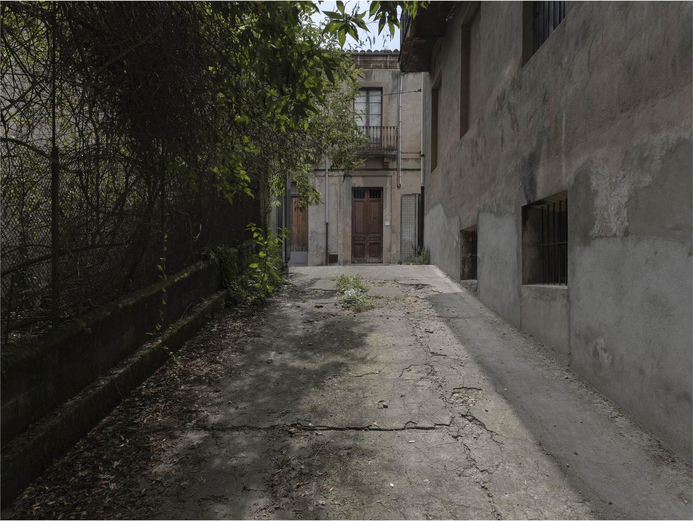 Patio de concreto agrietado con puerta al fondo