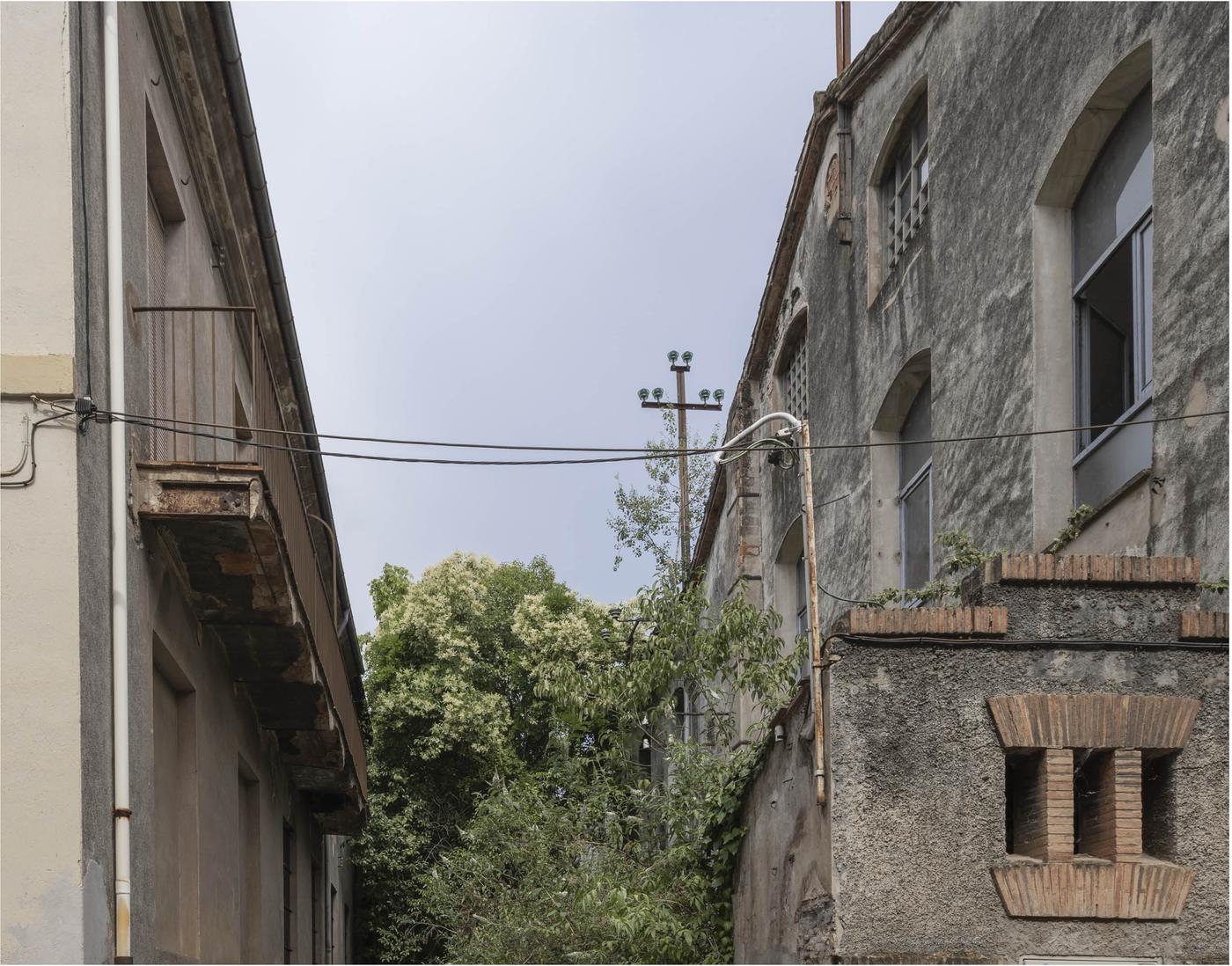 Callejón entre dos naves con cables tendidos